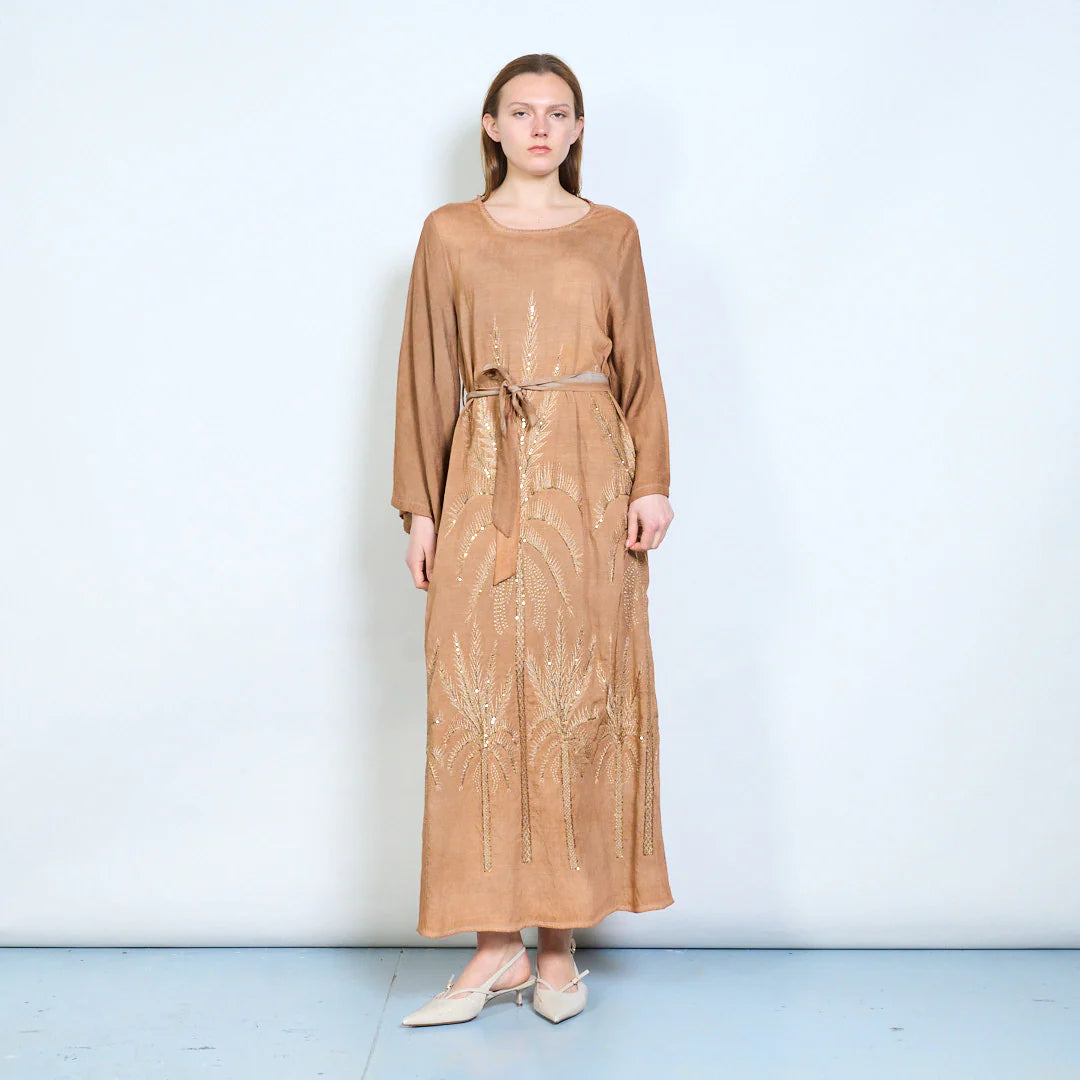 Abito lungo con maniche ampie, cintura e ricami decorativi