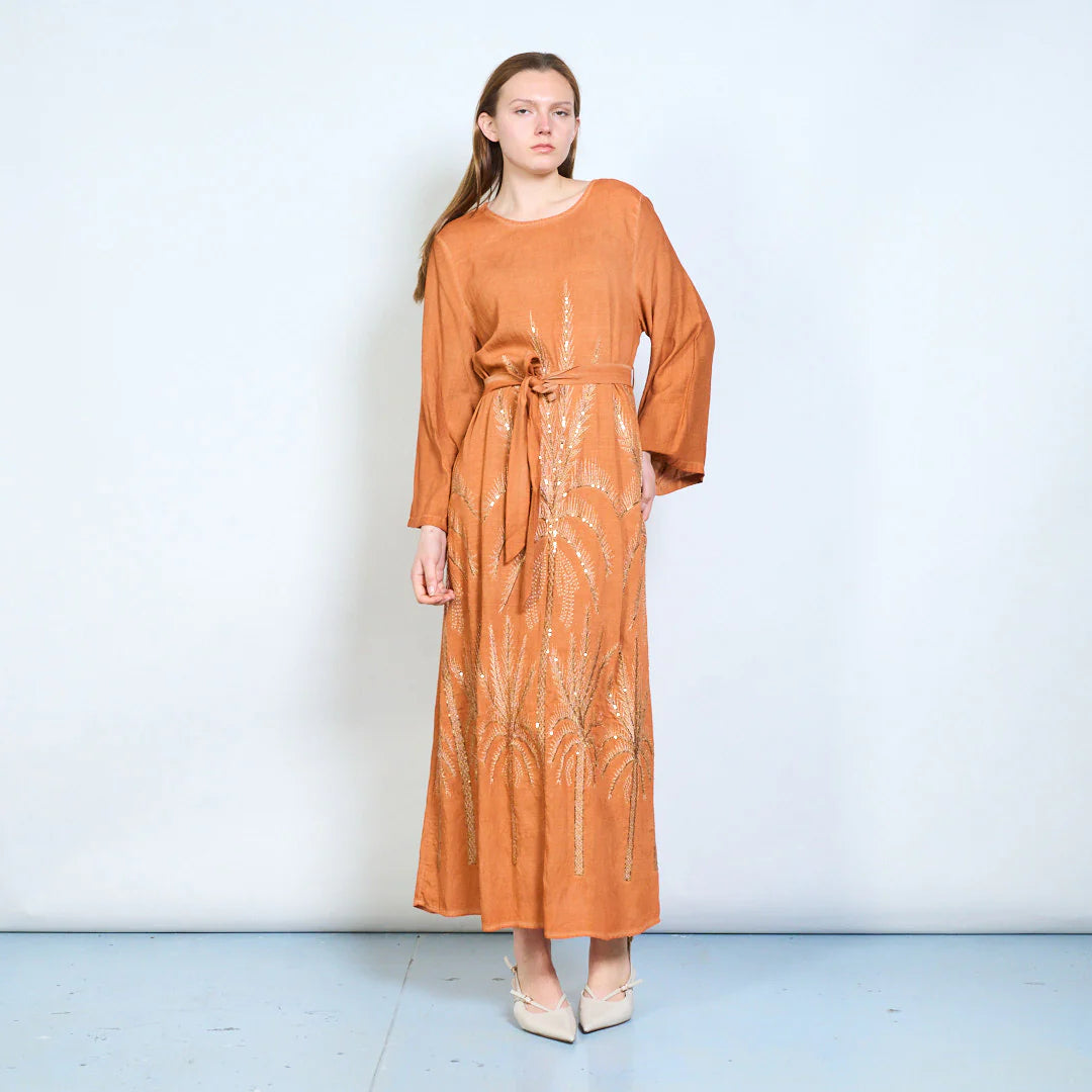 Abito lungo con maniche ampie, cintura e ricami decorativi