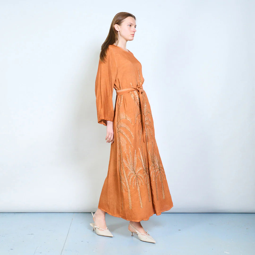 Abito lungo con maniche ampie, cintura e ricami decorativi